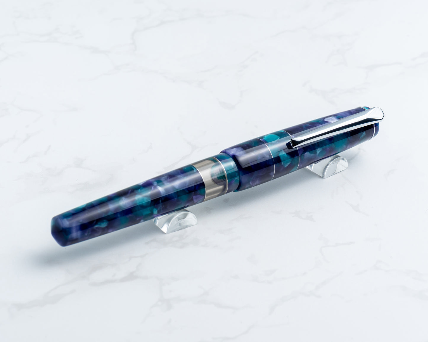 Blue and silver pen on a white stand against a white background