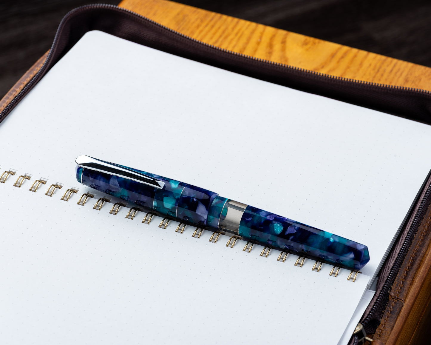 Fountain pen with blue and green marbled design on a notebook